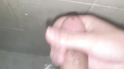 Horny dude is filming his cock under the shower while jerking off