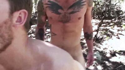 Inked guy is penetrating boyfriend's ass deep in the woods