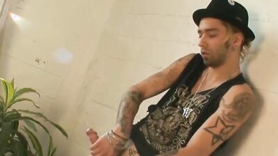 Tattooed bloke is playing with his pecker in the apartment