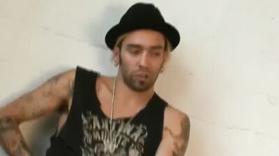 Tattooed bloke is playing with his pecker in the apartment