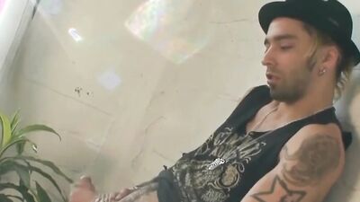 Tattooed bloke is playing with his pecker in the apartment