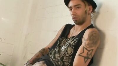Tattooed bloke is playing with his pecker in the apartment