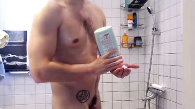 Tattooed and athletic guy takes a shower and jerks off