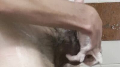 Slender bloke takes a steamy shower and strokes his huge cock