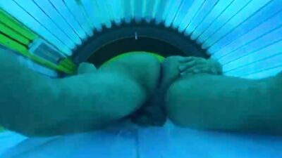 Horny stud strokes his fat dick and cums in a solarium
