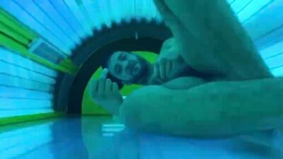Horny stud strokes his fat dick and cums in a solarium