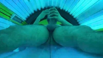 Horny stud strokes his fat dick and cums in a solarium