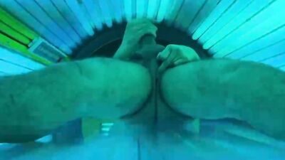 Horny stud strokes his fat dick and cums in a solarium