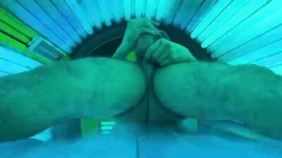 Horny stud strokes his fat dick and cums in a solarium