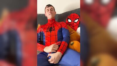 Naughty young dude in a Spiderman costume strokes his dick