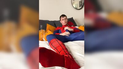 Naughty young dude in a Spiderman costume strokes his dick