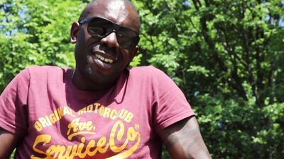Kinky black guy rubs oil on his feet and teases outdoors