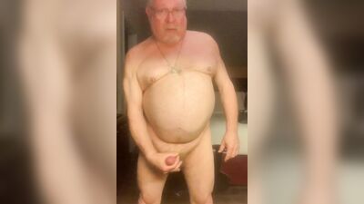 Chubby older guy with glasses strips and strokes his cock