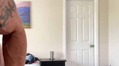 Muscular hunk tries out different clothes while teasing with a big hard cock