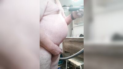 The fat guy pisses and plays with his shaved cock