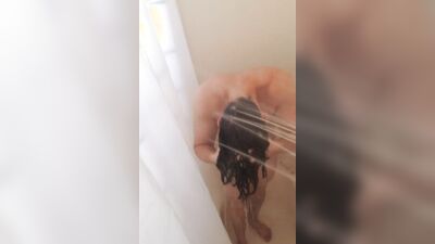 Cute twink with long hair jerks off while taking a shower