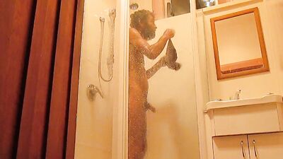 Bearded chap is filming himself while taking a hot shower