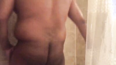 Chubby fellow is playing with a dick inside the hot shower