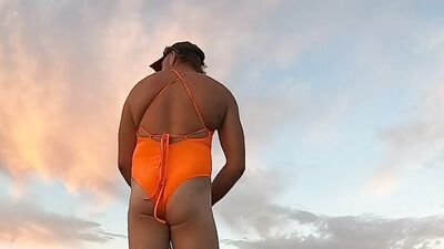 Orange one piece swimsuit down at the beach