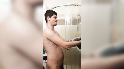 Cute gay bloke is masturbating while taking a hot shower