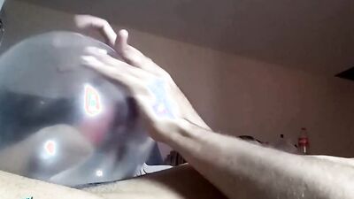 Naughty guy uses blown-up condom to play with his cock