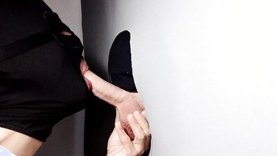 Gimp sucks a hard cock and deepthroats on it through a gloryhole.