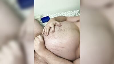 Fat guy is rubbed with oil while playing with his dick