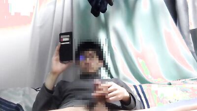 Asian guy is watching gay porn on his phone while jerking off
