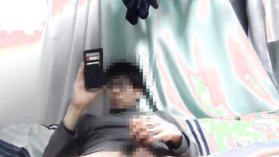 Asian guy is watching gay porn on his phone while jerking off