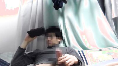 Asian guy is watching gay porn on his phone while jerking off