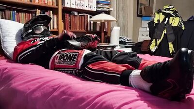 Horny biker is squeezing his dick while lying on that bed