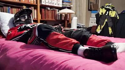 Horny biker is squeezing his dick while lying on that bed