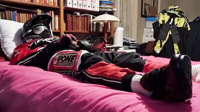 Horny biker is squeezing his dick while lying on that bed
