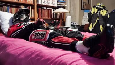Horny biker is squeezing his dick while lying on that bed