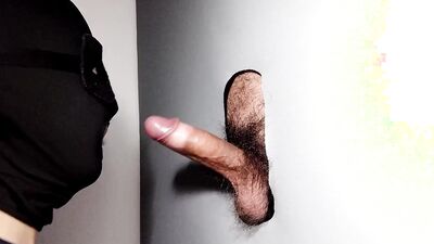 Cock is sucked through a gloryhole by a masked gimp