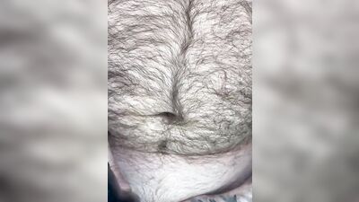 Hairy guy is jerking off while watching gay porn on his phone