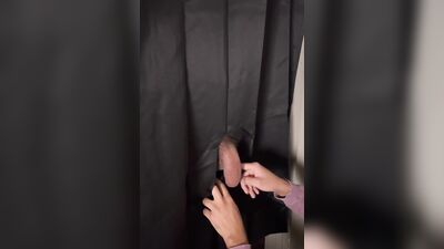 Masked gimp is passionately sucking a cock through that gloryhole