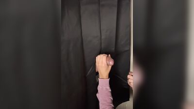 Masked gimp is passionately sucking a cock through that gloryhole