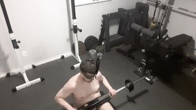 A security camera films a naked guy while he's working out
