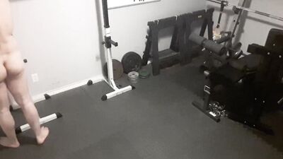 A security camera films a naked guy while he's working out