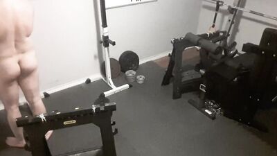 A security camera films a naked guy while he's working out