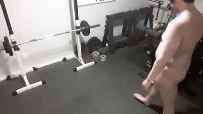 A security camera films a naked guy while he's working out
