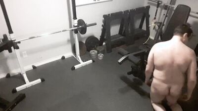A security camera films a naked guy while he's working out