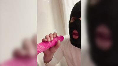 Masked gimp wraps his lips around a massive dildo and sucks it