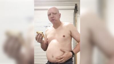 Chubby guy shows his belly while stuffing on the webcam
