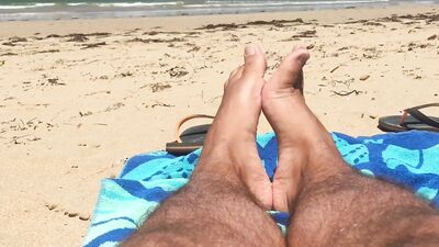 Kinky lad is filming his feet while chilling on the beach