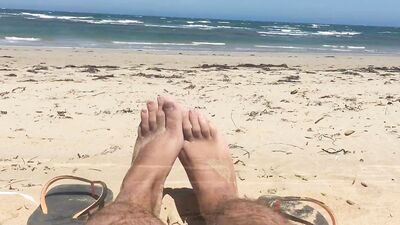 Kinky lad is filming his feet while chilling on the beach