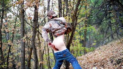 Skinny masked teen is playing with a pecker inside the forest