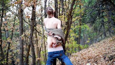 Skinny masked teen is playing with a pecker inside the forest