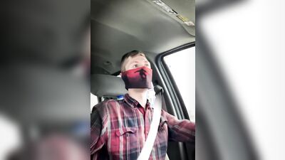 Amateur masked bloke is having fun while driving a car